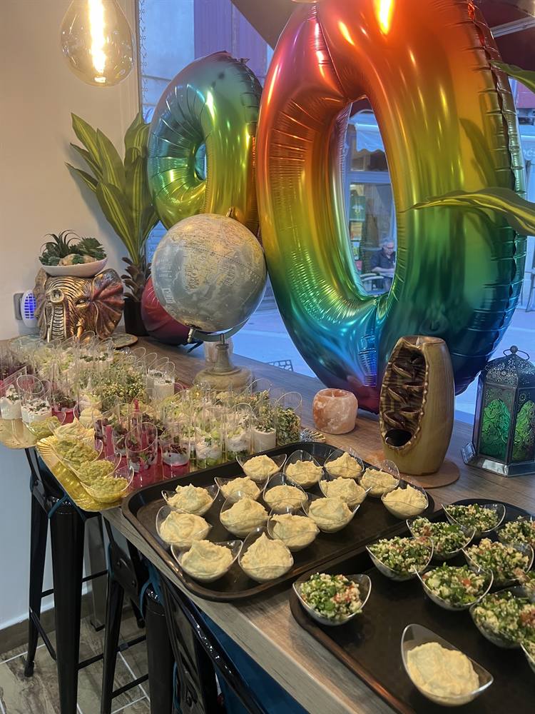 Buffet d'anniversaire avec ballons arc-en-ciel, verrines et feuilletés