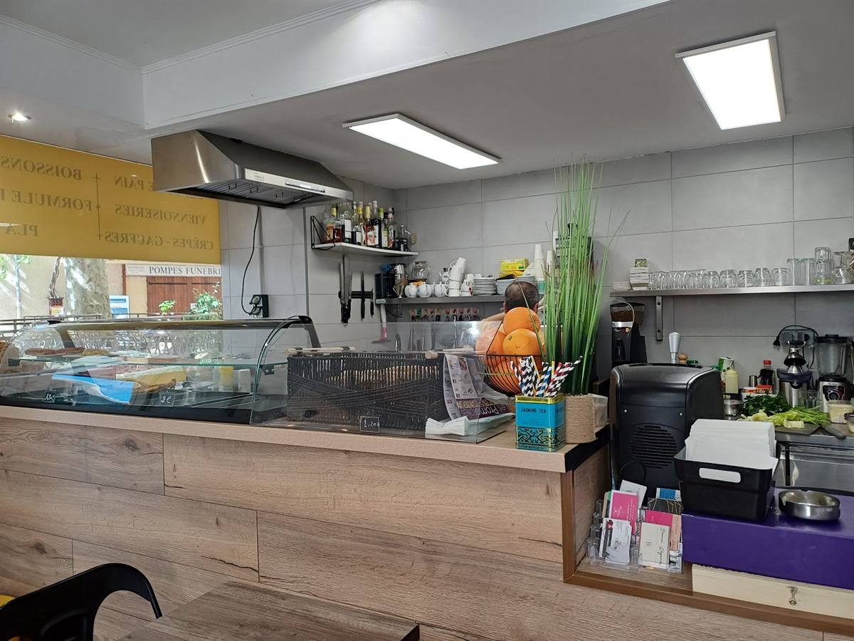 Le comptoir en bois, la machine à café et la vitrine