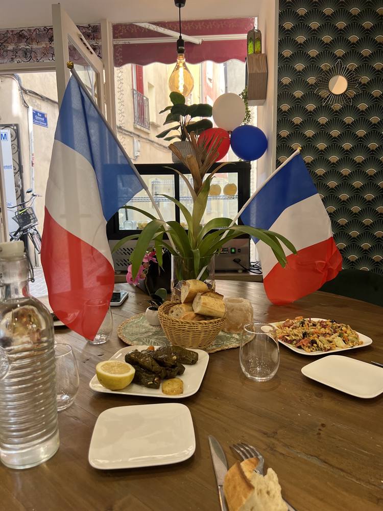 Table dressée pour le 14 juillet avec drapeaux, feuilles de vigne et pain