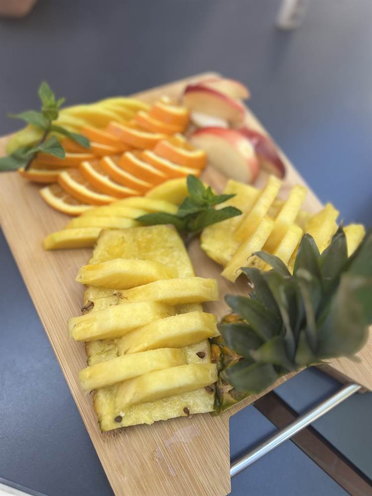 Planche de fruits frais : ananas, oranges et pommes