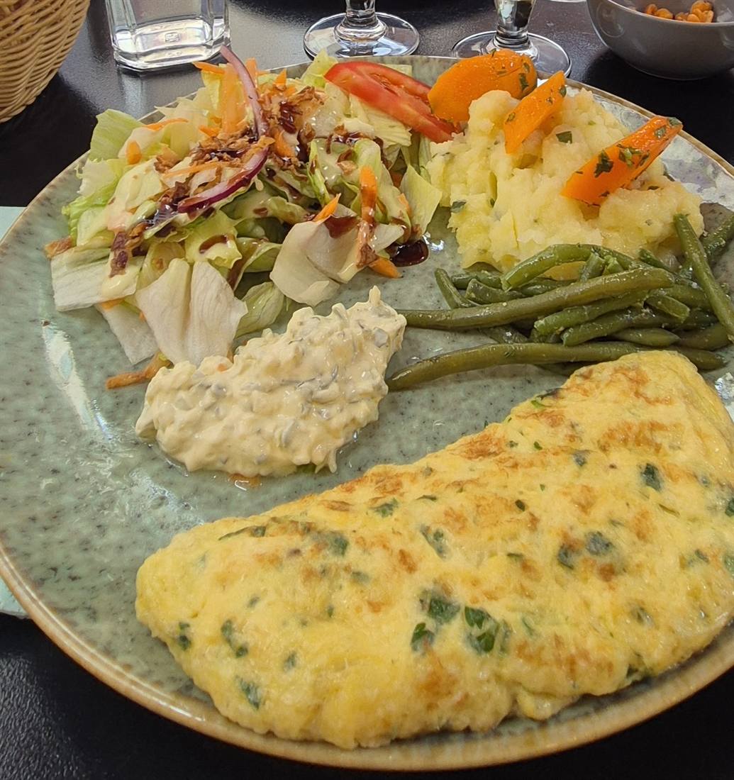 Omelette dorée aux herbes avec salade, haricots verts et écrasé de pommes de terre
