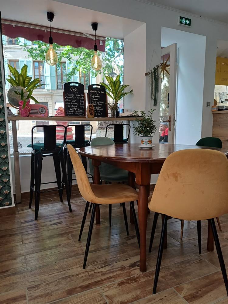 Chaises en velours moutarde autour d'une table ronde, ardoises au fond